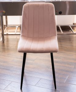 Silla Velvet rosa con costura vertical, patas de metal negro